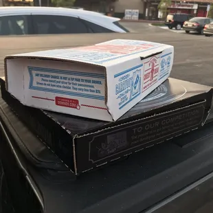 two pizza boxes stacked on top of each other