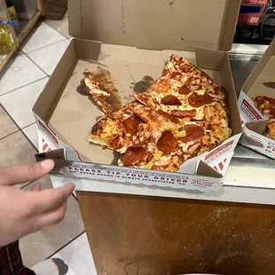 a slice of pepperoni pizza in a box