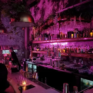 a dimly lit bar with bottles of alcohol