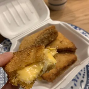 a hand holding a half eaten sandwich