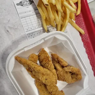 a tray of fried chicken and french fries