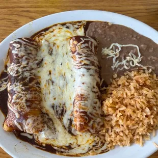 Enchilada meal with refried beans and rice.