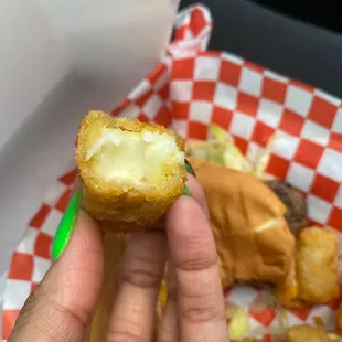 a hand holding a half eaten donut