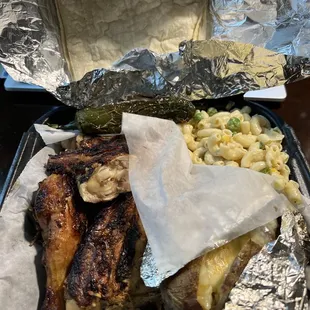 a tray of food that includes meat, macaroni, and cheese
