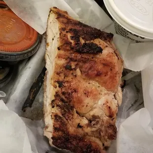 a tray of food with a sandwich and a side of sauces