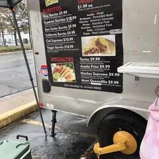 a little girl standing in front of a food truck