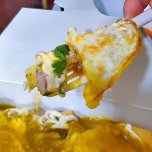 a hand holding a piece of pizza