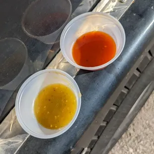 two cups of sauce on a grill