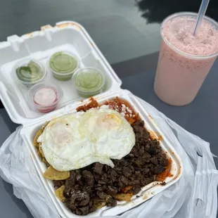 Red and green sauce chilaquiles with asada and over easy eggs + strawberry horchata
