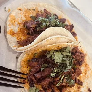 Tacos al pastor, the orange on the tortilla is the &quot;adobo&quot;, it is not cheddar cheese.