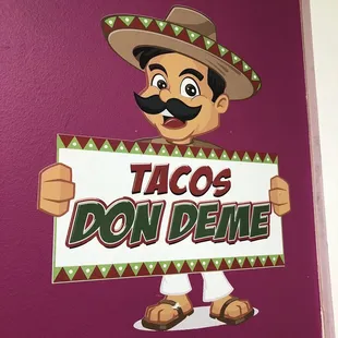 a mexican man holding a sign