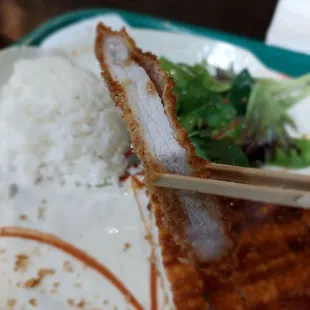 a plate of food with chopsticks and rice