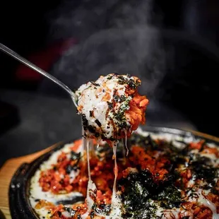 a pizza being lifted by a fork