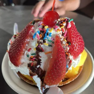 Waffle bowl w/a vanilla ice cream scoopx fresh ripe mangos, and strawberries, whipped cream, rainbow sprinkles and a drizzle of chocolate: