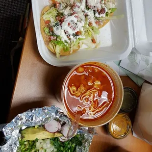 Pozole and garnish of onions, jalapeno, cilantro, radish, lettuce and acuacate, tostadas. 2 salsas to go with the chips.