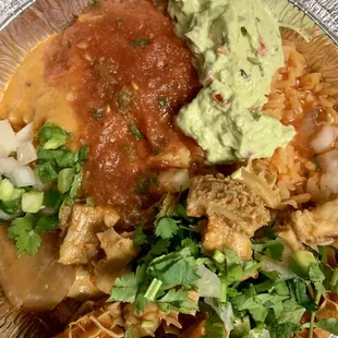Menudo over a bed of rice with garnishes