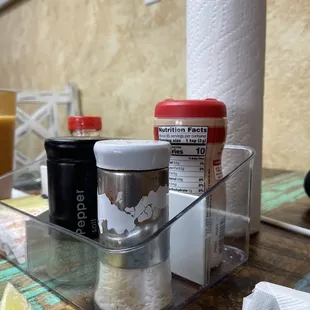 Large salt  and pepper shakers; also a regular roll of paper towels