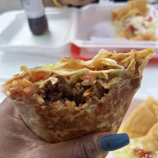 a hand holding a burrito