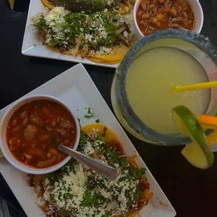 two plates of mexican food and a drink
