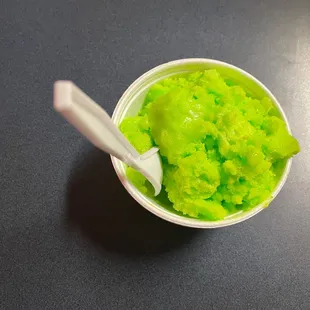 a bowl of green food with a spoon in it