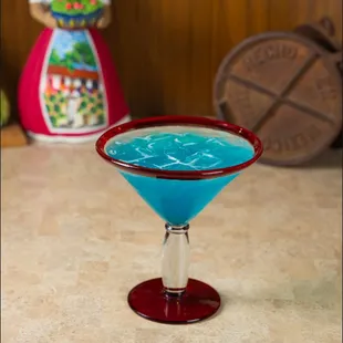 a blue cocktail in a martini glass