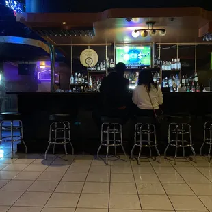 two people sitting at the bar