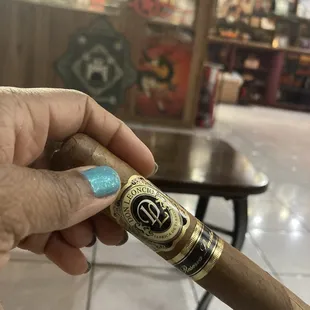 a hand holding a cigar