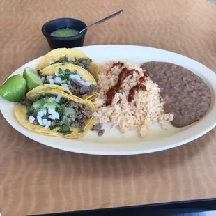 3 beef tacos on corn tortillas with rice ,beans , and salsa verde.