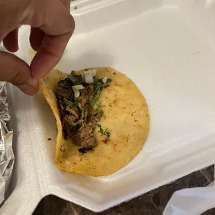 a hand picking up a taco