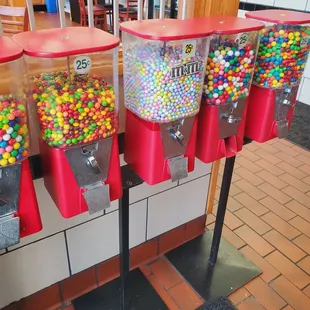 a row of gumballs dispensers