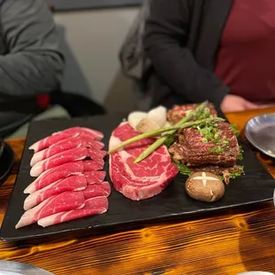 a variety of meats on a black plate