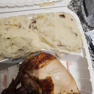 a chicken and mashed potatoes in a styrofoam container