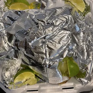 Carryout 8pc chicken to-go is packed with aluminum foil and limes nested in the corners