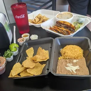 Birria tacos with rice, beans, and chips.