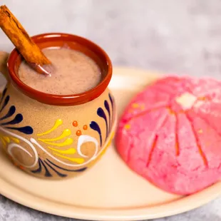 a cup of hot chocolate and a pink donut