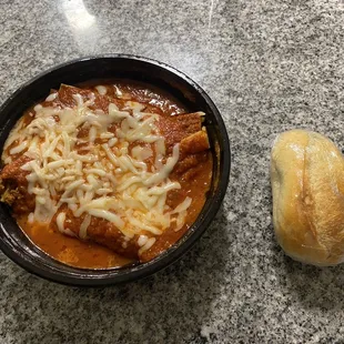 Meat Lasagna with marinara sauce and a bread roll that came with it. The takeout container is about 4 or 5 inches in diameter, for scale.