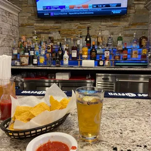 a bowl of chips and a glass of beer