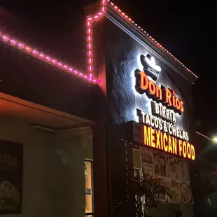 a mexican restaurant lit up at night