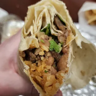 a hand holding a burrito