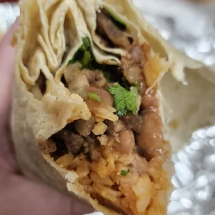 a hand holding a burrito