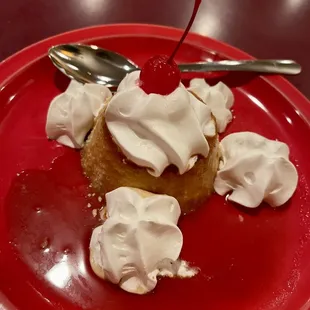 a dessert with whipped cream and a cherry on top