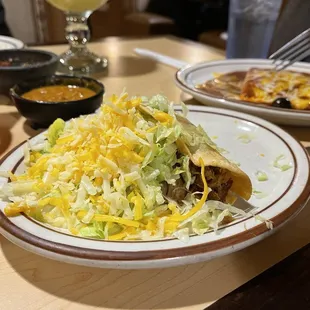 Hard shell taco with bean dip in the background. As you can see, they're generous with the fillings