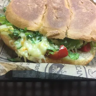 Tinga (chicken with onions and chipotle sauce) fajita veggies, lettuce, cheese, black beans, chipotle mayo, cilantro, torta (sandwich)