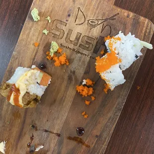 a wooden cutting board with sushi on it