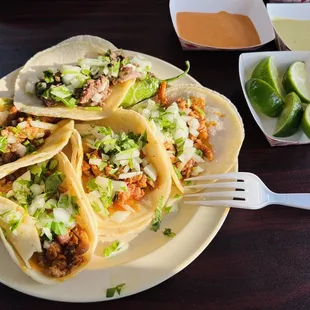 A mix of tacos - asada, al pastor (spicy pork), and chicken.