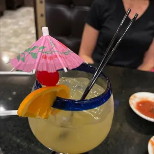 a woman sitting at a table with a drink