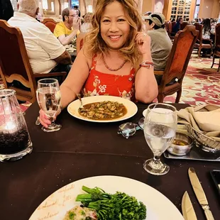 a woman sitting at a table with a plate of food