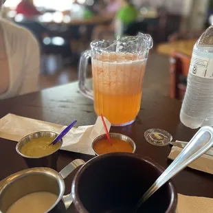 a glass of orange juice and two cups of coffee