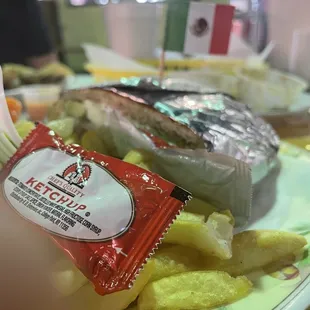a plate of french fries and a packet of ketchup