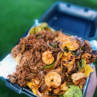 a hand holding a container of food